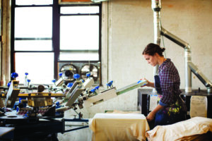 woman working in T-shirt screen-printing shop