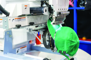 embroidery machine decorating a baseball hat