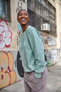 Female posing in sweatshirt graffiti in background